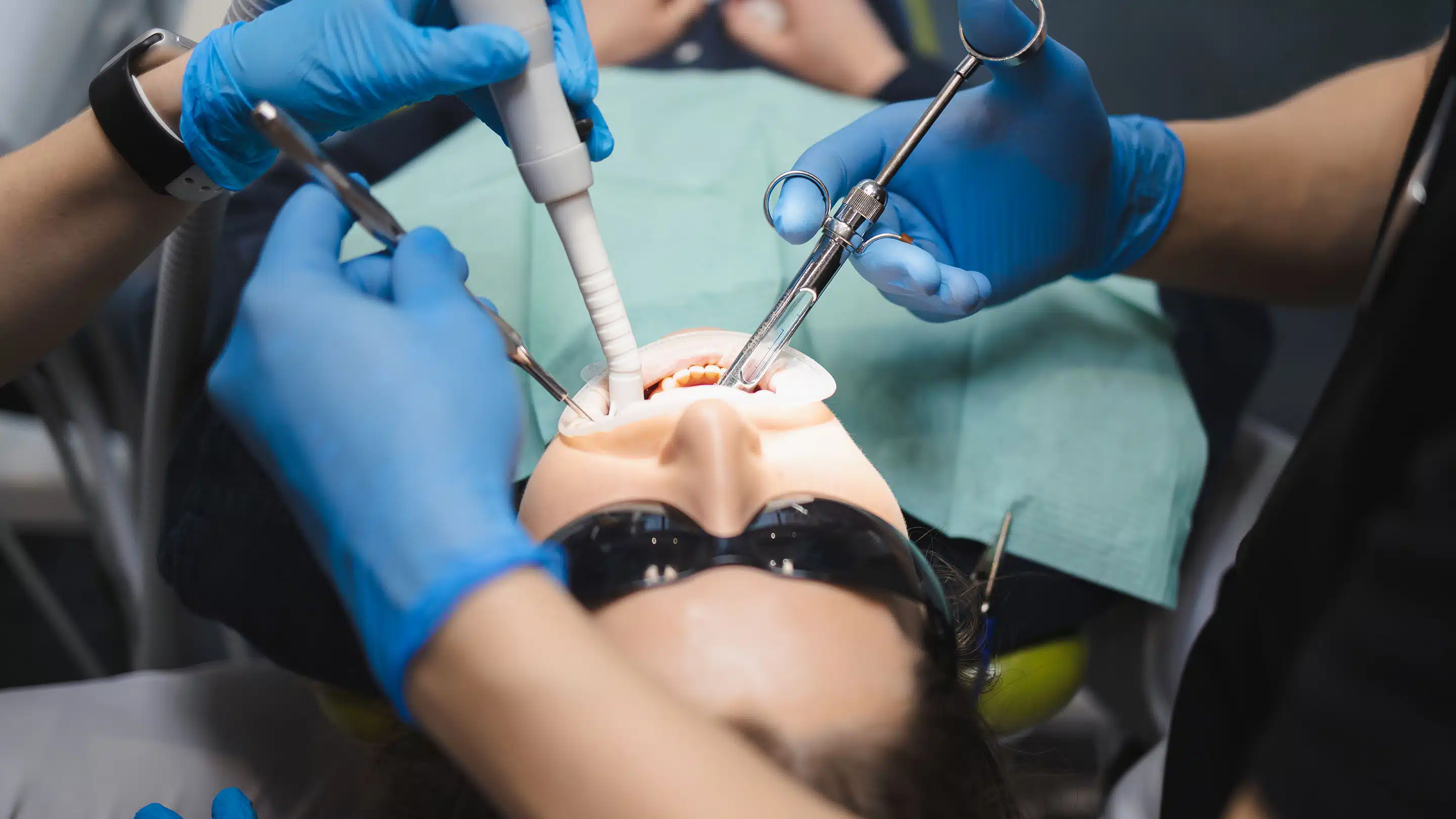 Dentist performing oral surgery and extraction