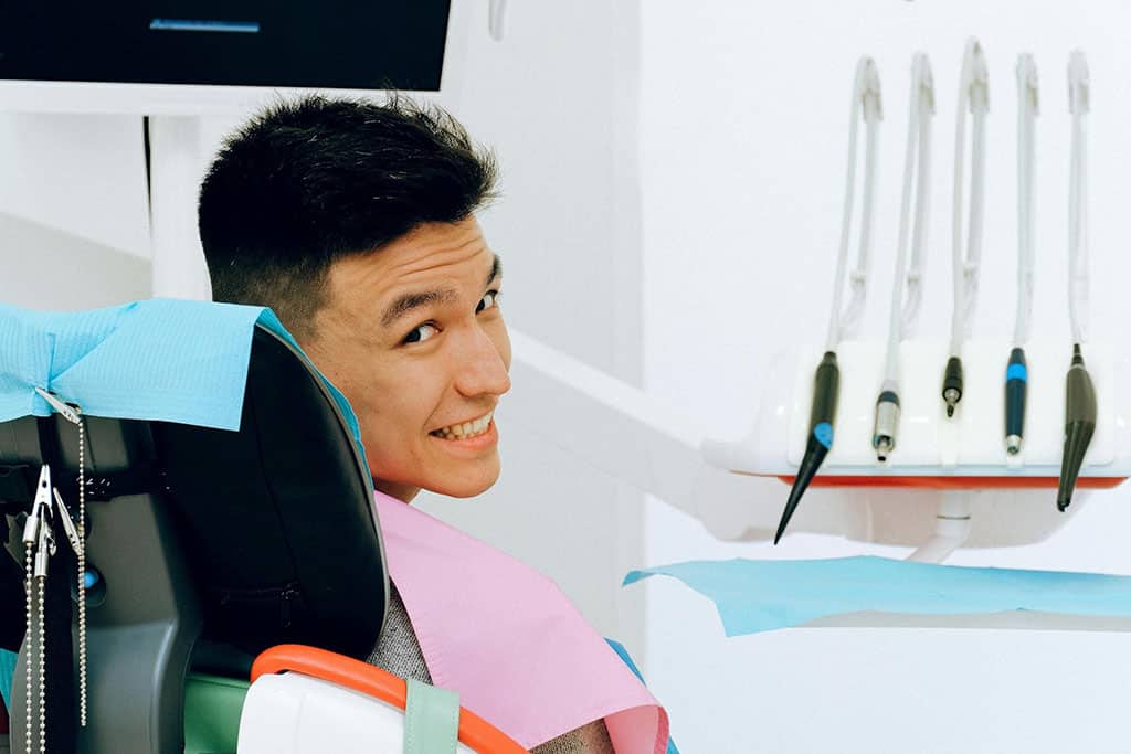 Smiling male patient sitting in a dental chair Smiling male patient sitting in a dental chair